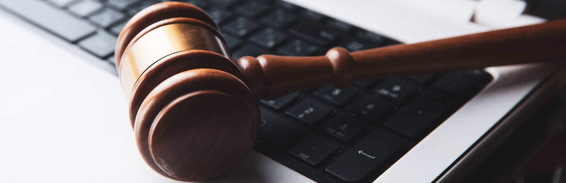 Fotografia de el teclado de una laptop con un gavel encima